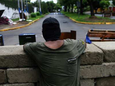 Un étudiant fait le guet sur une barricade dans la zone de l'Université nationale autonome du Nicaragua (UNAN), où des heurts avec la police sont survenus, le 23 juin 2018 à Managua - Marvin RECINOS [AFP]