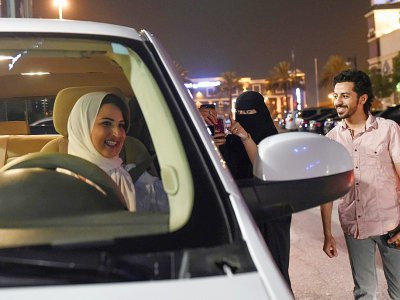 Une Saoudienne filme et apporte son soutien à Samar Al-Moqren (G) au volant de sa voiture à Ryad le 24 juin 2018, jour de la levée de l'interdiction aux femmes de conduire - FAYEZ NURELDINE [AFP]