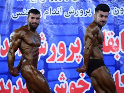 Hares Mohammadi (g), bodybuilder afghan, participe à un concours de bodybuilding et fitness, le 18 avril 2018 à Kaboul - WAKIL KOHSAR [AFP]