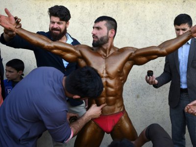 Hares Mohammadi, bodybuilder afghan, est enduit de faux bronzage pour participer à un concours de fitness, le 16 avril 2018 à Kaboul - WAKIL KOHSAR [AFP]