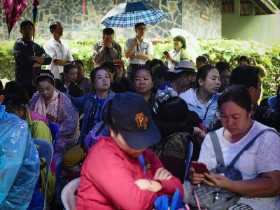 Des parents et proches attendent des nouvelles devant la grotte de Tham Luang, le 26 juin 2018 à Chiang Rai, en Thaïlande - LILLIAN SUWANRUMPHA [AFP]