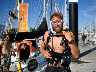 Le skipper néerlandais Mark Slats s'apprête à plonger pour  inspecter la coque de son bateau avant un tour du monde en solitaire, le 30 juin 2018 aux Sables d'Olonne - Damien MEYER [AFP]