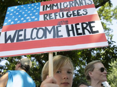 "Les immigrés et les réfugiés sont les bienvenus": un jeune manifestant, le 30 juin 2018 à Washington - Alex Edelman [AFP]