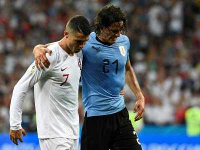 L'attaquant uruguayen Edinson Cavani (g), blessé, quitte le terrain soutenu par le Portugais Cristiano Ronaldo en 8e de finale du Mondial, le 30 juin 2018 à Sotchi - Jonathan NACKSTRAND [AFP]