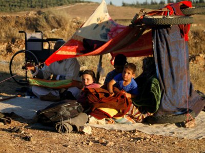 Des Syriens ayant fui les bombardements des forces pro-régime dans la province de Deraa attendant dans un camp de fortune près de la frontière jordanienne, dans le sud de la Syrie, le 1er juillet 2018 - Mohamad ABAZEED [AFP]