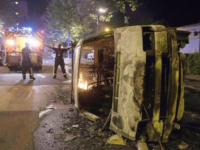 Des policiers près d'une voiture brûlée dans le quartier du Breil à Nantes le 4 juillet 2018 au petit matin - SEBASTIEN SALOM GOMIS [AFP/Archives]