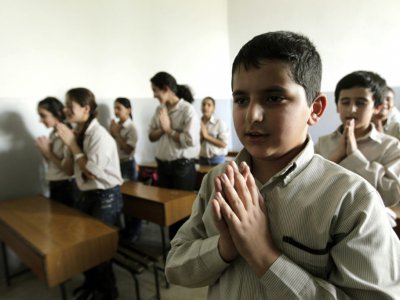 Des enfants chrétiens réfugiés d'Irak prient pendant le catéchisme dans une école catholique proche de Beyrouth le 15 novembre 2010 - JOSEPH EID [AFP/Archives]
