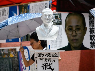 Un buste du prix Nobel Liu Xiaobo (C), décédé en juillet 2017, et un portrait de son épouse Liu Xia (D) lors d'une commémoration le 1er juin 2018 à Hong Kong avant le 29ème anniversaire de la répression en 1989 sur la place Tiananmen à Pékin - Anthony WALLACE [AFP/Archives]
