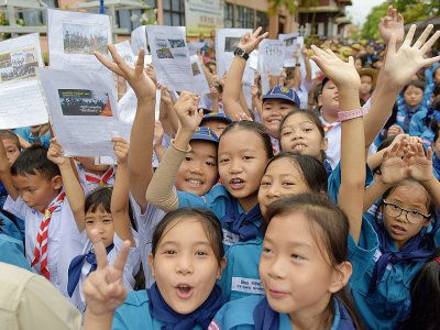 Des écoliers thaïlandais fêtent l'évacuation des jeunes gens bloqués 18 jours dans une grotte inonée, le 11 juillet 2018 à Chiang Rai - TANG CHHIN Sothy [AFP]