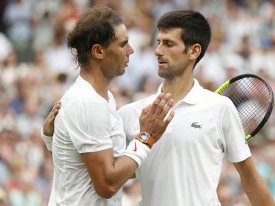 Rafael Nadal (d) donne l'accolade à Novak Djokovic après leur demi-finale de Wimbledon, le 14 juillet 2018 - NIC BOTHMA [POOL/AFP]