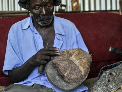 Un employé d'Alisam Products fabrique une casquette à partir de cuir de poisson, le 11 juin 2018 à Kisumu, au Kenya - TONY KARUMBA [AFP]