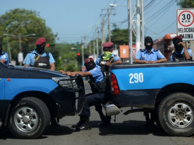 Des policiers en position autour d'une église où des étudiants s'étaient réfugiés, assiégés par les forces progouvernementales, le 14 juillet 2018 à Managua, au Nicaragua - MARVIN RECINOS [AFP]