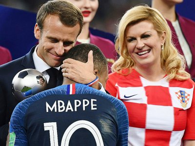 Le président français Emmanuel Macron félicite Kylian Mbappé sous les yeux de la présidente croate Kolinda Grabar-Kitarovic, après la finale du Mondial, le 15 juillet 2018 à Moscou - Jewel SAMAD [AFP]