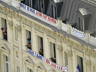 Des banderoles remerciant les Bleus sont accrochées sur un immeuble des Champs-Elysées à Paris, le 16 juillet 2018 - Bertrand GUAY [AFP]
