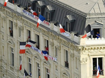 Drapeaux et banderoles sur un immeuble des Champs-Elysées - Bertrand GUAY [AFP]