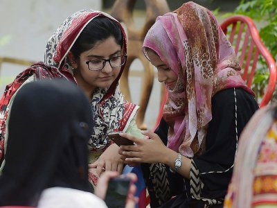 Des étudiantes utilisent leur smartphone sur le campus d'Islamabad le 12 juillet 2018 - Aamir QURESHI [AFP]