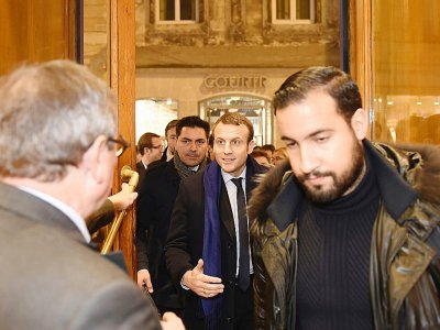 Emmanuel Macron (c, à l'époque candidat à la présidentielle, précédé par son garde du corps Alexandre Benalla (d), dans une librairie de Bordeaux, le 13 décembre 2016 - NICOLAS TUCAT [AFP/Archives]