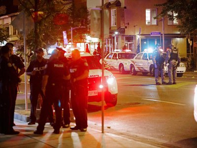 Des policiers de Toronto dans Danforth Street, sur la scène de la fusillade qui a fait deux morts, le 23 juillet 2018 au Canada - Cole BURSTON [AFP]