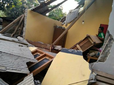 Un Indonésien dans les décombres d'une maison de Lombok en Indonésie après un tremblement de terre, le 29 juillet 2018 (Photo transmise par l'agence indonésienne de gestion des catastrophes) - Handout [Nusa Tenggara Barat Disaster Mitigation Agency/AFP]