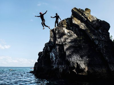 Des personnes se jettent à l'eau lors d'une sortie de coasteering ou  canyoning côtier, le 25 juillet 2018 à Morgat dans le Finistère - Fred TANNEAU [AFP]