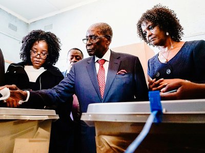 L'ancien président du Zimbabwe Robert Mugabe, entouré de sa fille Bona et de sa femme Grace, vote à Harare lors des élections générales le 30 juillet 2018. - Zinyange AUNTONY [AFP]