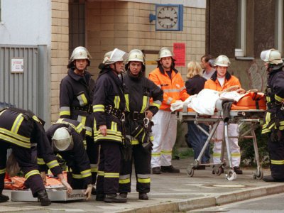 Des secouristes prennent soin des personnes blessées le 27 juillet 2000 lors d'un attentat raciste à Düsseldorf (Allemagne) dont le seul suspect a été acquitté - Christian OHLIG [dpa/AFP]