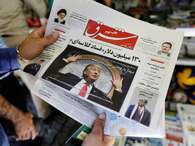 Un homme regarde la Une d'un quotidien iranien avec la photo du président américain Donald Trump, le 31 juillet 2018 à Téhéran - ATTA KENARE [AFP]