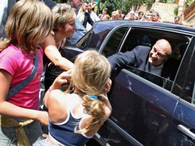 Le président Jacques Chirac salue des personnes le 8 août 2005 après avoir assisté à l'office religieux dominical en l'église de Bormes-les-Mimosas en compagnie de son épouse Bernadette. - ERIC ESTRADE [AFP]
