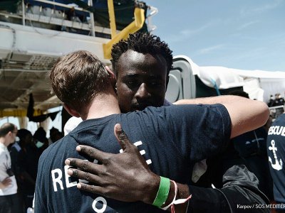 Cette photo distribuée par Médecins sans frontières et SOS Méditerranée montre un migrant de l'Aquarius donnant l'accolade à un sauveteur le 17 juin 2018 à Valence - Karpov [SOS MEDITERRANEE/AFP]