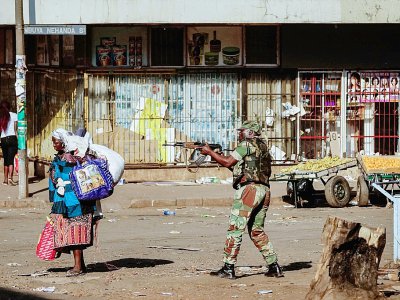 Un soldat zimbabwéen met en joue une femme à Harare, après des affrontementsentre forces de l'ordre et partisans de l'opposition qui dénoncent des fraudes après les élections générales, le 1er août 2018 à Harare - Zinyange AUNTONY [AFP]