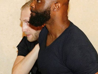Le rappeur français Kaaris est escorté par la police au tribunal de Créteil, dans la banlieue de Paris, le 3 août 2018 - Geoffroy VAN DER HASSELT [AFP]