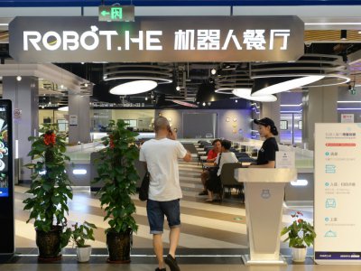 Un client entre dans le restaurant Robot.He, le 30 juillet 2018 à Shanghai, en Chine - - [AFP]
