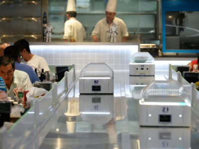 Des robots serveurs au restaurant Robot.He, le 30 juillet 2018 à Shanghai, en Chine - - [AFP]