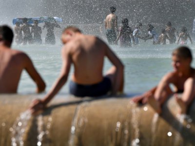 Des personnes se rafraîchissent dans le bassin de la fontaine du Trocadéro, le 2 août 2018 à Paris, pendant un épisode de canicule - GERARD JULIEN [AFP]