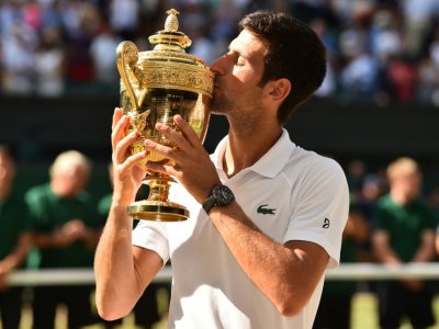 Le Serbe Novak Djokovic embrasse le trophée après avoir remporté Wimbledon aux dépens du Sud-Africain Kevin Anderson, le 15 juillet 2018 - Glyn KIRK [AFP/Archives]