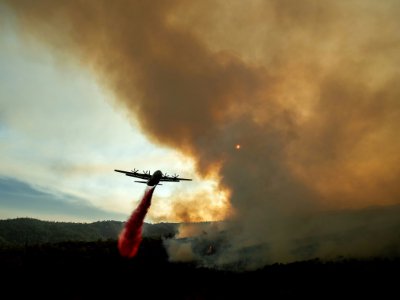 Un avion citerne un produit ignifugeant pour freiner le Ranch Fire, incendie faisant partie du Mendocino Complex, le plus grand feu de l'histoire de la Californie, près de la localité de Clealarke Oaks, le 5 août 2018 - NOAH BERGER [AFP]