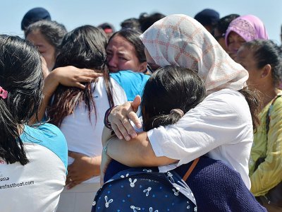 Des Indonésiens retrouvent leurs familles au port de Bangsal, le 7 août 2018 après avoir été évacués des îles Gili - ADEK BERRY [AFP]