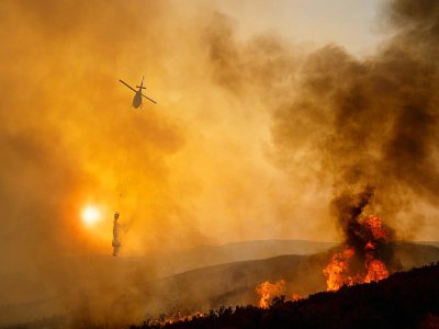 Un hélicoptère participe à la lutte contre un brasier de l'incendie "Mendocino Complex" près de Clearlake Oaks en Californie, le 5 août 2018 - NOAH BERGER [AFP]