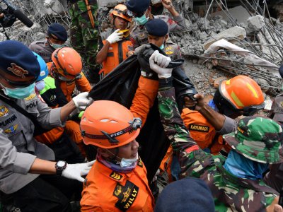 Des secouristes transportent le 8 août 2018 à Bangsal la dépouille d'une victime d'un séisme meurtrier en Indonésie - ADEK BERRY [AFP]