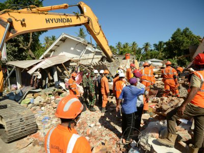 Recherches dans les décombres de bâtiments effondrés, le 8 août 2018 à Sigar Penjalin, en Indonésie, après le sésime meurtrier de dimanche sur l'île de Lombok - SONNY TUMBELAKA [AFP]