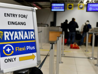 Des passagers au comptoir de la compagnie low-cost irlandaise Ryanair à l'aéroport de Berlin-Schoenefeld, le 22 décembre 2017 - Bernd Settnik [dpa/AFP/Archives]