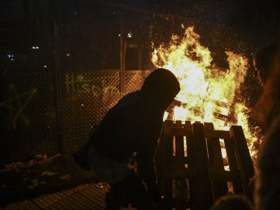 Une poignée de manifestants isolés ont incendié des palettes contre une des deux rangées de grilles séparant les camps du "oui" et du "non" au projet de loi, à Buenos Aires le 09 août 2018 - EITAN ABRAMOVICH [AFP]