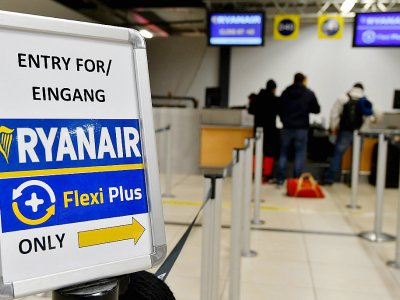 Des passagers au comptoir de la compagnie low-cost irlandaise Ryanair à l'aéroport de Berlin-Schoenefeld, le 22 décembre 2017 - Bernd Settnik [dpa/AFP/Archives]