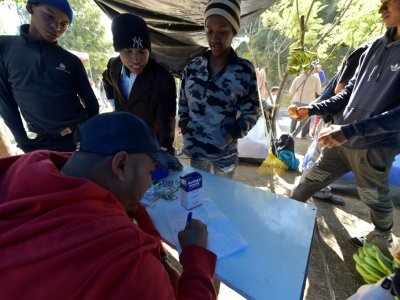 Un homme qui travaillait dans un service d'urgences au Venezuela donne des consultations médicales improvisées à ses compatriotes, dans un campement de fortune près d'une gare de bus, le 9 août 2018 à Quito, en Equateur - RODRIGO BUENDIA [AFP]