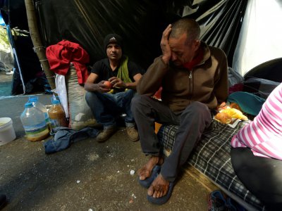 Le Vénézuélien José Carrizales (d) dans un campement de fortune près d'une gare de bus, le 9 août 2018 à Quito, en Equateur - RODRIGO BUENDIA [AFP]