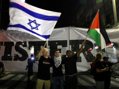 Des drapeaux israélien et palestinien brandis lors d'une manifestation d'Arabes israéliens contre une loi définissant Israël comme "l'Etat-nation du peuple juif", le 11 août 2018 à Tel-Aviv - Ahmad GHARABLI [AFP]