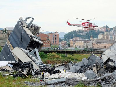 Un hélicoptère des sauveteurs survole une section du viaduc de l'A10 après son effondrement, le 14 août 2018 à Gênes, dans le nord de l'Italie - ANDREA LEONI [AFP]