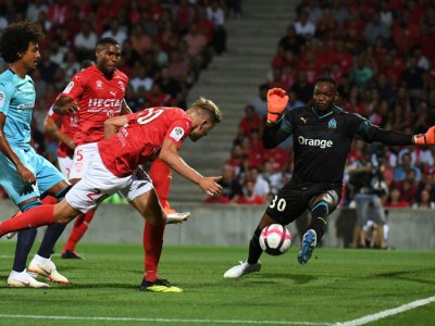 Le gardien de l'OM Steve Mandanda (d) en difficulté lors du match de Ligue 1 perdu à Nîmes, le 19 août 2018 - PASCAL GUYOT [AFP/Archives]