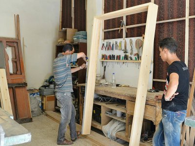Le menuisier Houssam Obeid se prépare à rouvrir son atelier dans la ville de Saqba, le 13 août 2018 - Maher AL MOUNES [AFP]