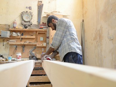 Un menuisier syrien effectue des mesures dans l'atelier du fabriquant de meubles Youssef al-Qabouni à Saqba, près de Damas le 13 août 2018 - Maher AL MOUNES [AFP]